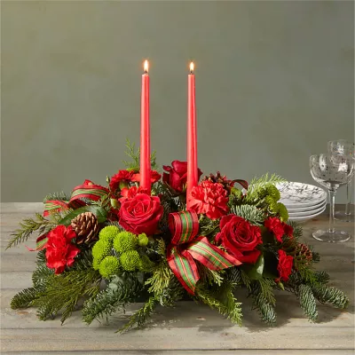 Let time fly By the Candlelight centerpiece as new holiday memories are made. What better way to commemorate the joyful homecoming than with classic red roses and lush evergreen accents?